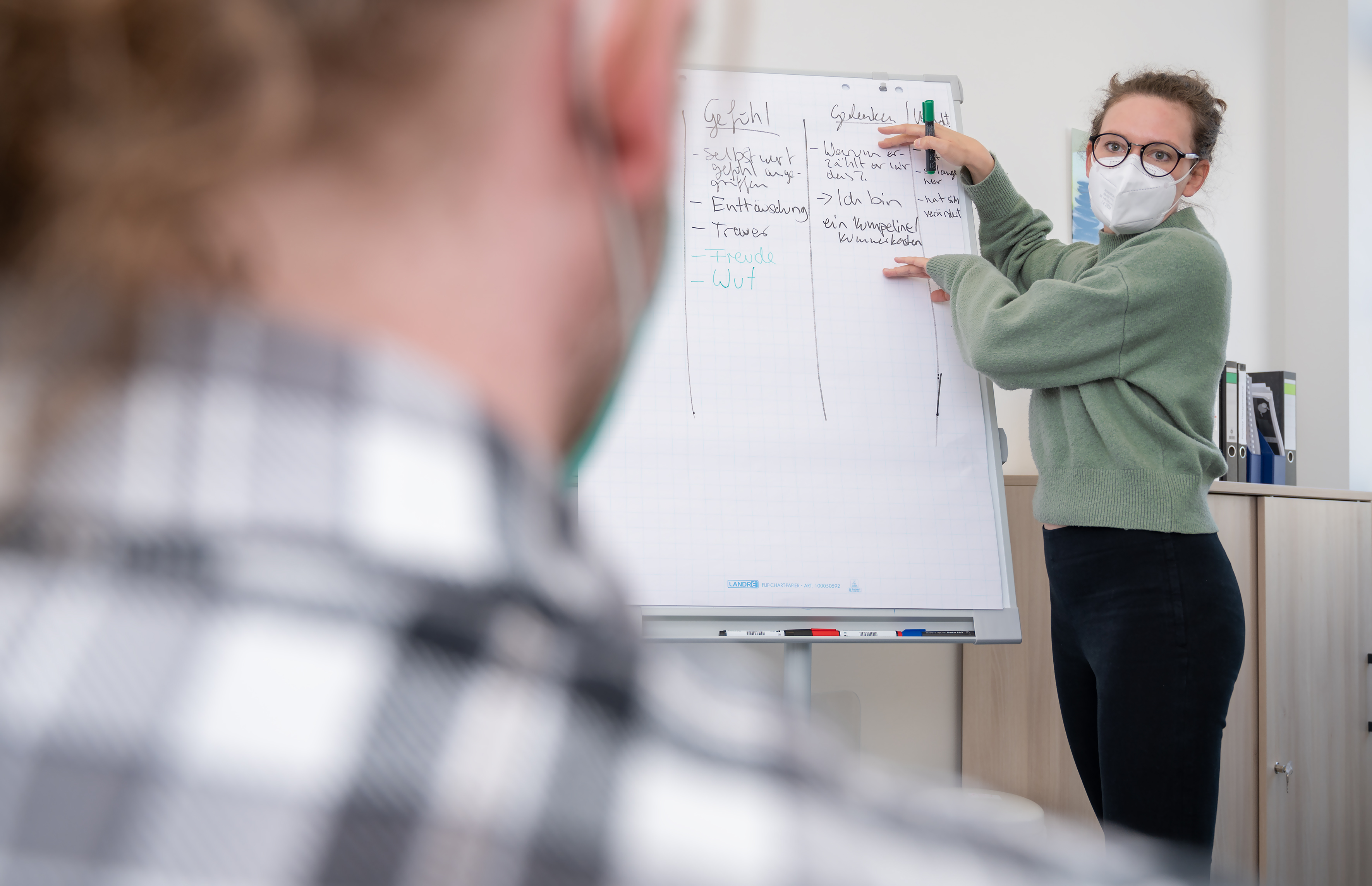 Frau am Flipchart, ein Zuhörer