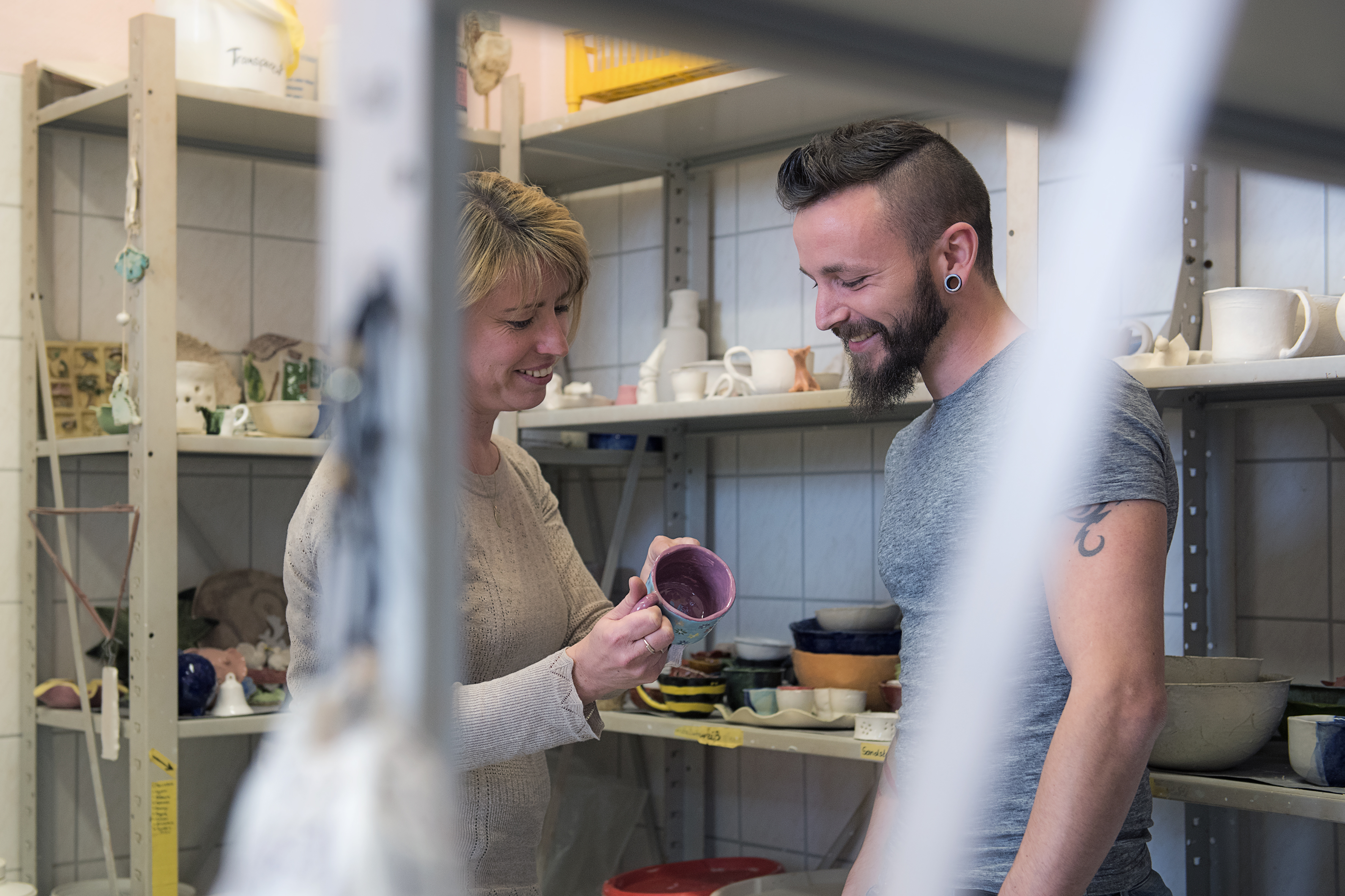 Frau und Mann betrachten Töpferstücke