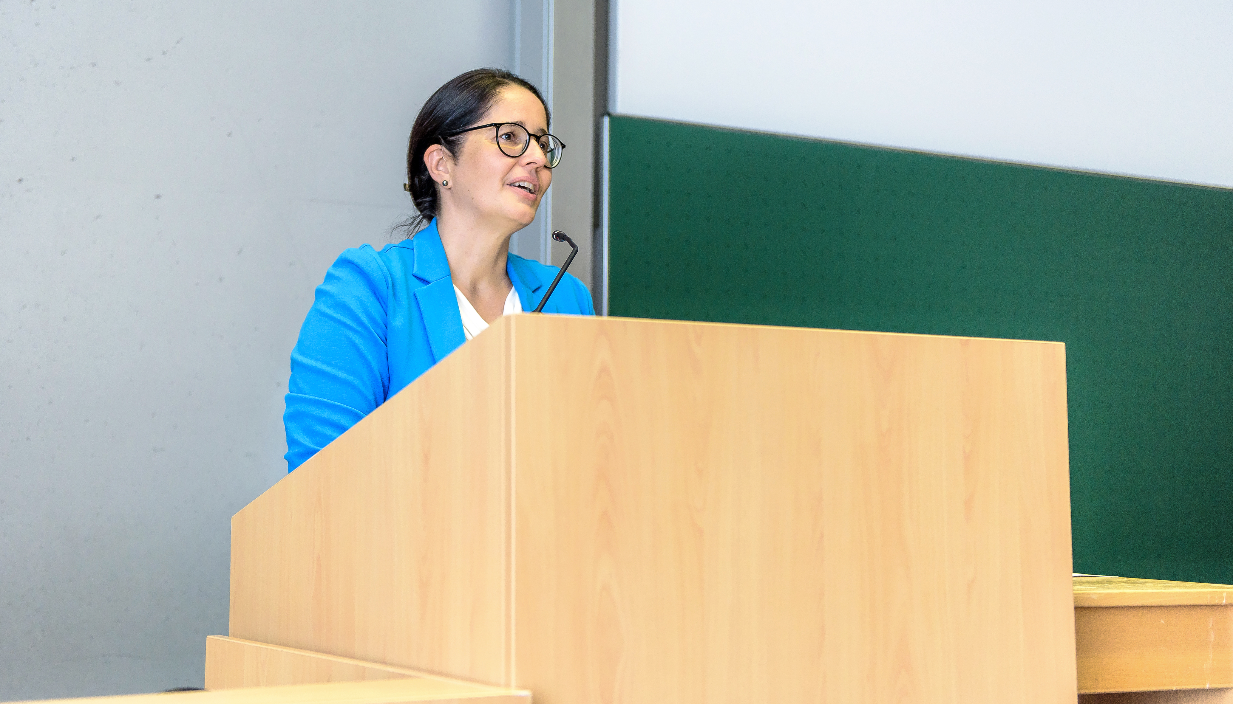 Pflegedirektorin Christiane Becker steht in einem Hörsaal an einem Rednerpult und hält ein Grußwort.