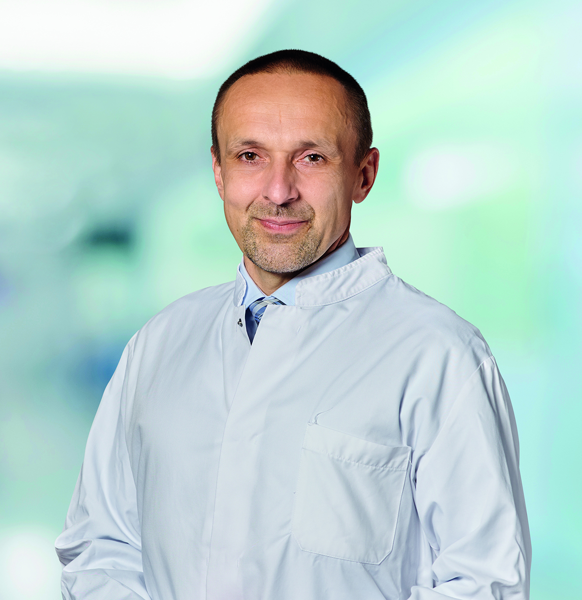 Porträt von Prof. Dr. Marcus Krüger. Er trägt einen Arztkittel.