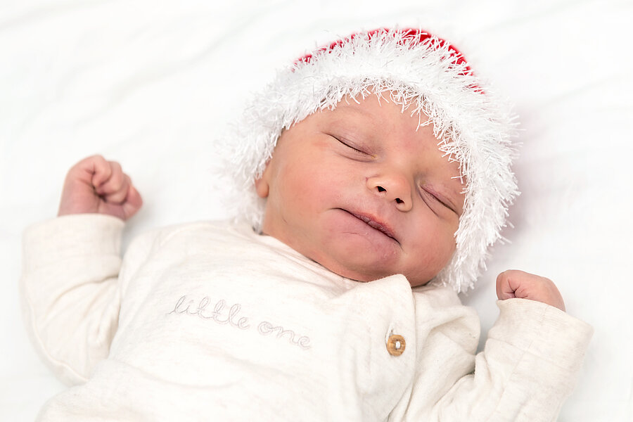 Neugeborenes Baby auf weißen Untergrund mit einer Weihnachtsmannmütze  Neugeborenes Baby auf weißen Untergrund mit einer Weihnachtsmannmütze