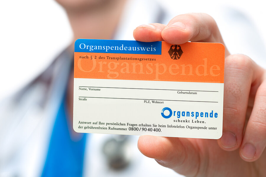 Detailaufnahme: Eine Hand hält einen Organspendeausweis in die Kamera. Detailaufnahme: Eine Hand hält einen Organspendeausweis in die Kamera.