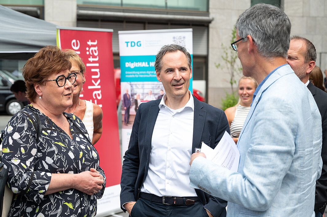 Ministerin Petra Grimm-Benne, Prof. Dr. Daniel Sedding und Bürgermeister Egbert Geier im Gespräch auf dem Marktplatz in Halle (Saale)