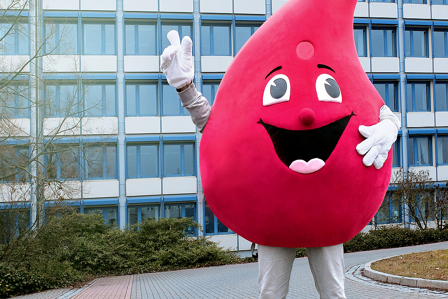 Das Maskottchen der Blutspende des Universitätsklinikums Halle (Saale), ein großer Blutstropfen mit Gesicht, steht vor dem Verlagsgebäude der MZ in Halle (Saale). Es handelt sich um ein mehrstöckiges Bürogebäude. Auf dem Dach steht der Schriftzug „Mitteldeutsche Zeitung“. Das Maskottchen der Blutspende des Universitätsklinikums Halle (Saale), ein großer Blutstropfen mit Gesicht, steht vor dem Verlagsgebäude der MZ in Halle (Saale). Es handelt sich um ein mehrstöckiges Bürogebäude. Auf dem Dach steht der Schriftzug „Mitteldeutsche Zeitung“.