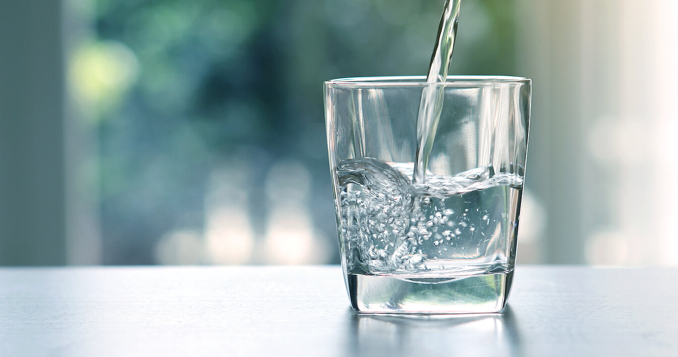 Wasser fließt in ein Glas